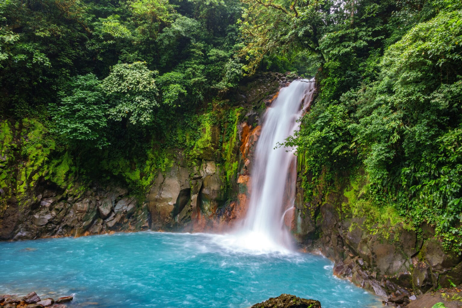 Top view long exposure of celestial blue waterfall and pond in volcan tenorio national park, Costa Rica
